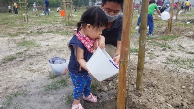 小朋友植樹後為小樹苗澆水