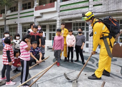 森林護管員向學童示範使用火拍拍打滅火