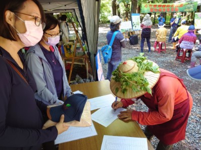 居民用小花蔓澤蘭裝飾斗笠來參與移除活動